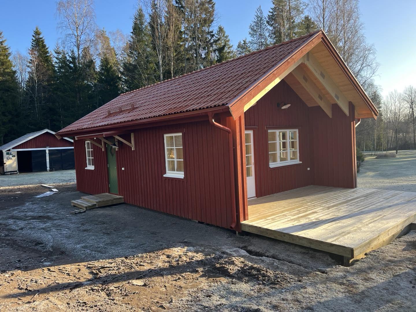 Nybyggd stuga med altan och trall i trä